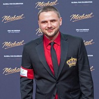 Kakak Bigi, Prince Jackson, memadukan jas hitam dengan kemeja merah. Pria 29 tahun ini terlihat selalu melempar senyum lebar ke awak media. Foto: WireImage/Tristar Media
