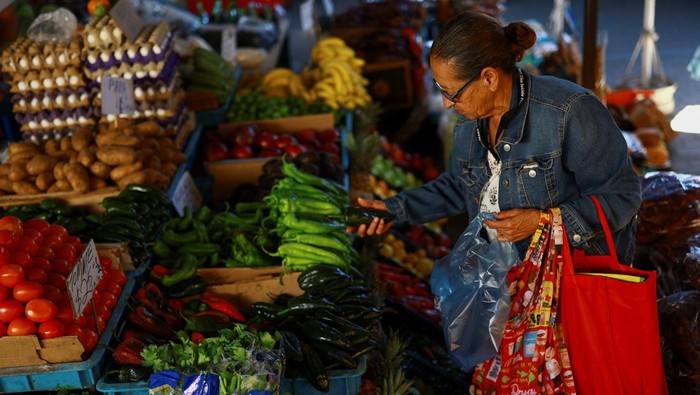 A worker sells fruits and vegetables at a market following a March's inflation surge driven by rising food and energy prices, in Ciudad Juarez, Mexico, April 15, 2026. REUTERS/Jose Luis Gonzalez
