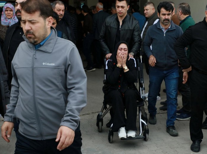 People stand in front of a school where a shooting took place early in the day, in the Turkey's southeastern province of Kahramanmaras, Turkey, April 15, 2026. REUTERS/Ensar Ozdemir