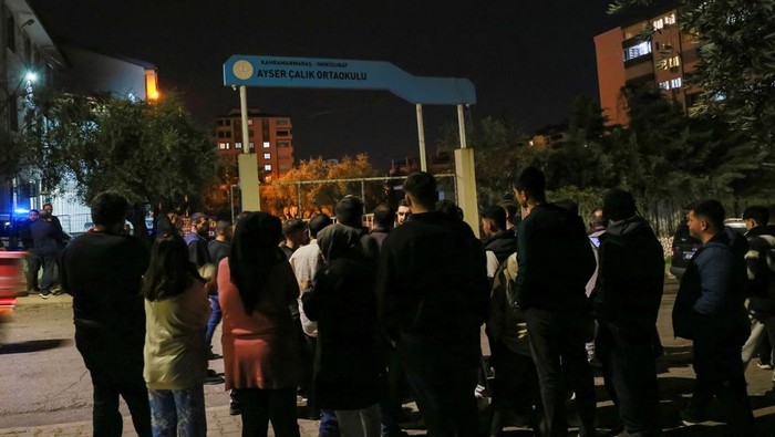 People stand in front of a school where a shooting took place early in the day, in the Turkey's southeastern province of Kahramanmaras, Turkey, April 15, 2026. REUTERS/Ensar Ozdemir
