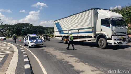 Polisi menabur pasir pada titik terdampak tumpahan oli di Bundaran Giri Menang Square (GMS), Lombok Barat, Kamis (16/4/2026).