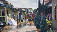 Anggota TNI dan petugas dari dinas terkait turut membantu warga Joyotakan membersihkan lingkungan setelah banjir surut.
