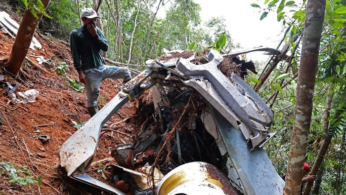 Seorang warga menutup hidung saat melihat puing-puing Helikopter Airbus H130 registrasi PK-CFX yang jatuh di kawasan Bukit Puntak, Desa Tapang Tingang, Kecamatan Nanga Taman, Kabupaten Sekadau, Kalimantan Barat, Jumat (17/4/2026). Helikopter Airbus H130 PK-CFX milik Matthew Air Nusantara dengan pilot Capt Marindra Wibowo bersama kopilot Harun Arasyid itu mengalami kecelakaan pada Kamis (16/4) yang menewaskan dua awak beserta enam penumpang, dan seluruh jenazah telah dievakuasi ke Pontianak. ANTARA FOTO/Jessica Wuysang
