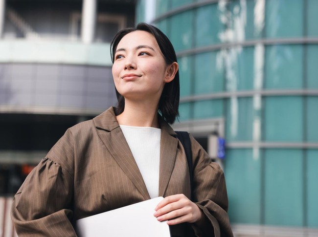 Asian Business Woman looking away camera In Outdoors,  Young woman on her morning commute.Woman heading to work happily with a cheerful expression on her face.