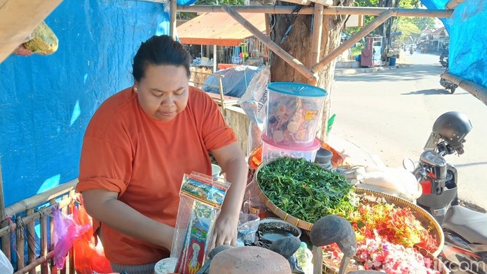 Nurhayati, penjual sesajen di Pasar Baru Indramayu, sedang melayani pembeli.