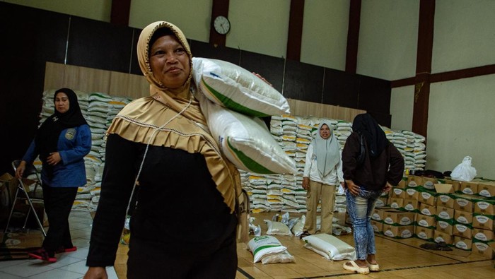 Warga membopong beras dan minyak goreng saat penyaluran bantuan pangan nasional di Kantor Desa Cibiru Wetan, Kabupaten Bandung, Jawa Barat, Jumat (17/4/2026). Badan Pangan Nasional (Bapanas) memastikan realisasi penyaluran bantuan pangan beras dan minyak goreng hingga Maret telah mencapai 382.529 penerima di 24 provinsi dengan target realisasi 33,2 juta penerima manfaat dari masyarakat berpenghasilan rendah. ANTARA FOTO/Novrian Arbi/foc.