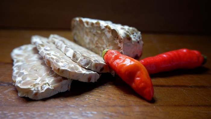 Close up of Red Pepper with tempeh a traditional food from Indonesia made from fermented soybeans. It is made by a natural culturing and controlled fermentation process that binds soybeans into a cake form. A fungus, Rhizopus oligosporus or Rhizopus oryzae, is used in the fermentation process and is also known as tempeh starter.