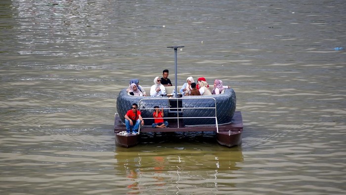 Foto udara pengunjung menaiki kafe terapung di Sungai Batang Arau, Padang, Sumatera Barat, Sabtu (18/4/2026). Sebuah kafe di Muara Padang menawarkan sensasi baru menikmati kuliner sambil menyusuri sungai legendaris di kawasan kota tua dengan menggunakan perahu yang dimodifikasi menjadi kursi dan meja makan dan bisa diisi hingga 10 orang. ANTARA FOTO/Fitra Yogi/bar