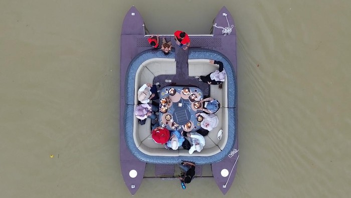 Foto udara pengunjung menaiki kafe terapung di Sungai Batang Arau, Padang, Sumatera Barat, Sabtu (18/4/2026). Sebuah kafe di Muara Padang menawarkan sensasi baru menikmati kuliner sambil menyusuri sungai legendaris di kawasan kota tua dengan menggunakan perahu yang dimodifikasi menjadi kursi dan meja makan dan bisa diisi hingga 10 orang. ANTARA FOTO/Fitra Yogi/bar