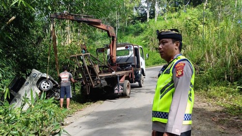 Mobil pemedek terperosok ke kebun warga di jalur Batusesa-Tegenan, Kecamatan Rendang, Karangasem, saat hendak sembahyang ke Pura Besakih dievakuasi menggunakan mobil derek, Sabtu (18/4/2026). (Dok. Polsek Rendang)