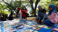 Pengunjung bersama anak memilih buku dalam kegiatan Minggu Baca Ramai Ramai di Blang Padang, Aceh. ANTARA FOTO/Akramul Muslim