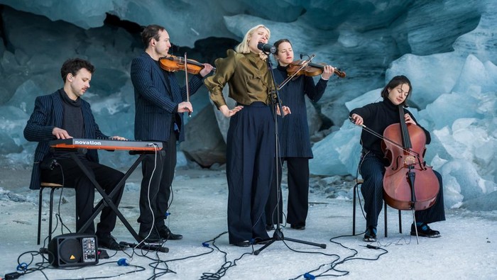 Swiss musician To Athena accompanied by a small group of musicians performs inside a cave carved into the Morteratsch glacier to draw attention on climate change, in Pontresina, Switzerland, March 25, 2026. GREENPEACE/Handout via REUTERS    THIS IMAGE HAS BEEN SUPPLIED BY A THIRD PARTY