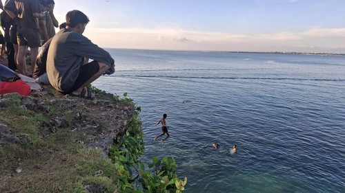 Sejumlah pemuda mencoba olahraga cliff jumping di Honeymoon Beach, Kelurahan Jimbaran, Kecamatan Kuta Selatan, Badung, Minggu (19/4/2026). (Fabiola Dianira/detikBali)