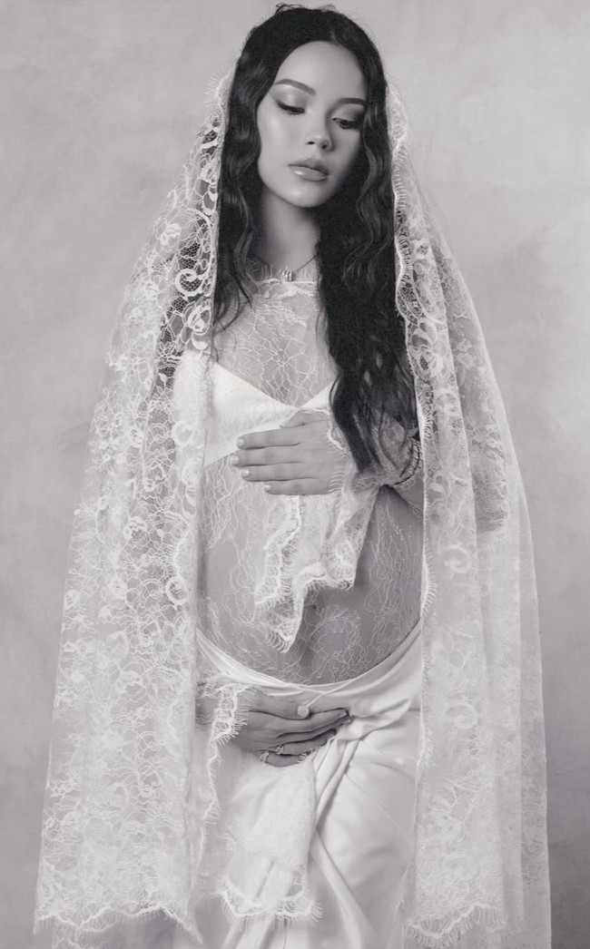 Alyssa tampil dalam  balutan lace transparan yang feminin. Ia mengenakan atasan berbahan lace tipis transparan dengan motif floral yang halus. Material ini memberikan kesan delicate sekaligus menonjolkan keindahan bentuk perut kehamilannya. Foto: Instagram/@alyssadaguise