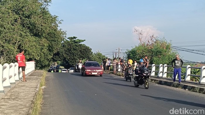 Beberapa warga Desa Singajaya , Kecamatan Balongan, Kabupaten Indramayu, berkumpul di jembatan setempat untuk menanti surak dari iring-iringan jemaah haji, Senin (20/4/2026).