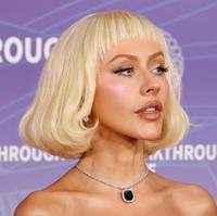 Wajahnya dipercantik riasan bergaya vintage dengan winged eyeliner, alis bersudut tinggi, serta bibir nude bergaya overline yang memberi efek lebih tebal. Foto: Getty Images