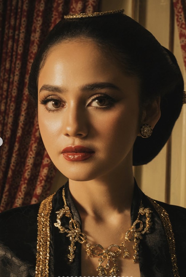 Makeup Syifa terlihat natural dengan sentuhan bold di bagian mata dan bibir. Mempermanis tampilannya, ia juga menambahkan sepasang giwang di telinga dan kalung emas yang serasi dengan busana yang dikenakan. Foto: Instagram/@elelrumi