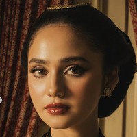 Makeup Syifa terlihat natural dengan sentuhan bold di bagian mata dan bibir. Mempermanis tampilannya, ia juga menambahkan sepasang giwang di telinga dan kalung emas yang serasi dengan busana yang dikenakan. Foto: Instagram/@elelrumi