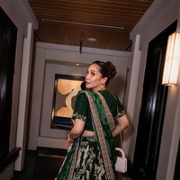 Nagita tampil lebih glam dengan lehenga hijau emerald yang dipenuhi bordir emas dan silver. Lehenga tersebut juga dipenuhi dengan motif floral yang cantik. Ia melengkapi penampilannya dengan selendang panjang dupatta yang disampirkan di bahu. Foto: Instagram/@raffinagita1717