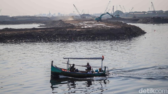 Sejumlah nelayan melintasi proyek reklamasi di kawasan laut Teluk Jakarta, tepatnya di Cilincing, Jakarta Utara, Senin (20/4/2026). Di tengah hamparan laut yang kini dipenuhi aktivitas pembangunan, perahu-perahu nelayan tampak bergerak perlahan, menc