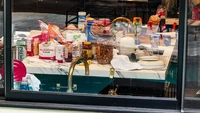 Bagian yang paling berantakan adalah area dapur, di mana penuh dengan makanan, seperti potongan pretzel, saus Chic-fil-A, bagel, sirup, saus tomat, tepung, sereal, serta perlengkapan memasak di atasnya. Foto: KONY / BACKGRID via New York Post