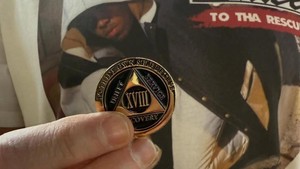 Koin itu bukan sembarangan. Koin menandai tonggak penting bertuliskan to thine own self be true terukir di tepi luar koin. Ada juga tulisan unity, service, recovery dengan angka 18 terukir dalam angka Romawi. XVIII🏅, tulis Eminem.  Foto: Dok.Eminem/ Instagram