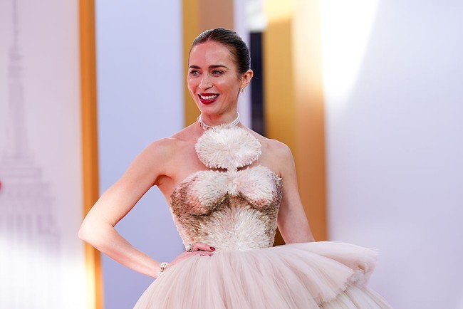 Rok berhias bulu itu terhubung dengan bodice pendek beraksen siluet bayangan khas rumah mode tersebut serta detail pom-pom besar. Ia melengkapi tampilan dengan sepatu hak terbuka bertali berwarna cokelat muda. (Foto: John Nacion/Variety via Getty Images)