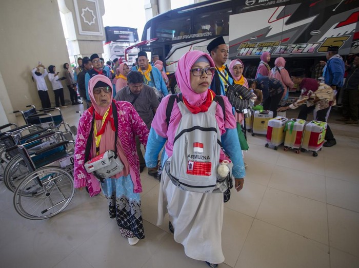 Jamaah calon haji turun dari bus setibanya di Asrama Haji Indramayu, Jawa Barat, Selasa (21/4/2026). Sebanyak 441 jamaah calon haji dan empat orang petugas haji kelompok terbang (kloter) pertama embarkasi Kertajati yang berasal Kabupaten Indramayu masuk ke asrama untuk transit dan beristirahat sebelum diberangkatkan ke Arab Saudi melalui Bandara Kertajati. ANTARA FOTO/Dedi Suwidiantoro/hma