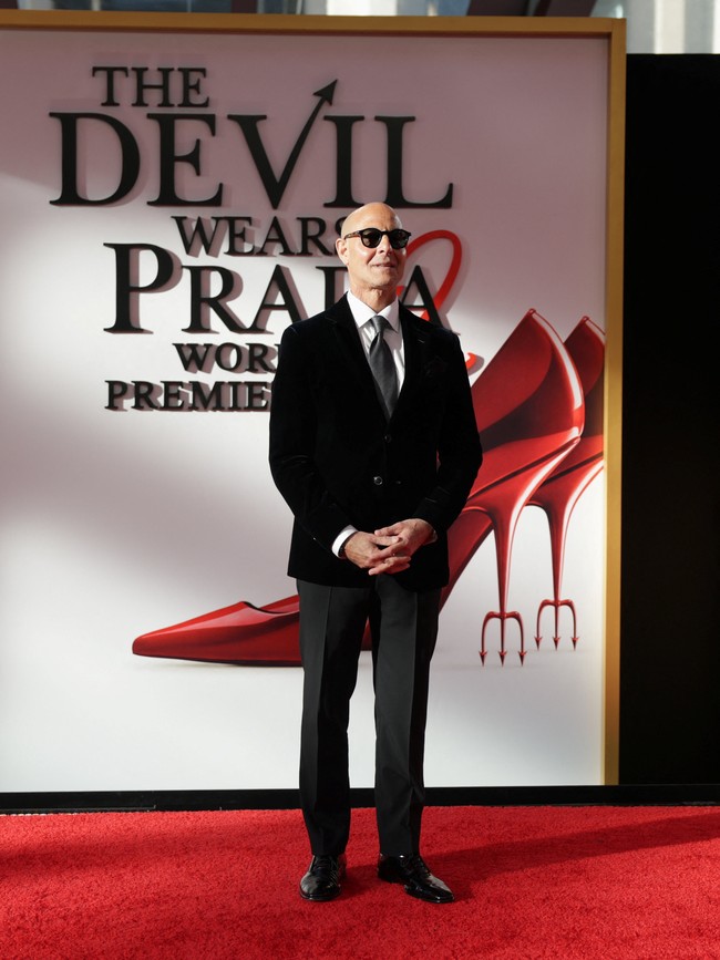 Dengan kacamata hitam khasnya, Stanley Tucci tampil di karpet merah mengenakan setelan Armani yang mencerminkan gaya karakter Nigel nan necis. Ia memadukan jaket beludru hitam dengan celana potongan ramping, kemeja putih, dasi abu-abu, serta saputangan saku senada. (Foto: REUTERS/Jeenah Moon)