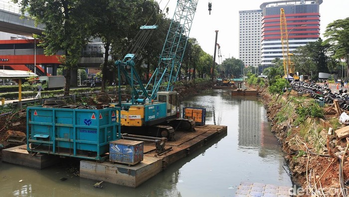 Para pekerja menyelesaikan proyek penguatan tanggul turap di kawasan Kuningan, Jakarta Selatan, Selasa (21/4/2026).
