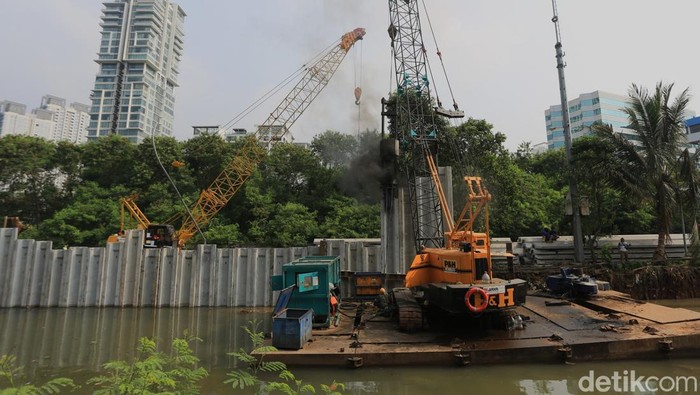 Para pekerja menyelesaikan proyek penguatan tanggul turap di kawasan Kuningan, Jakarta Selatan, Selasa (21/4/2026).