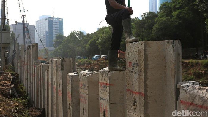 Para pekerja menyelesaikan proyek penguatan tanggul turap di kawasan Kuningan, Jakarta Selatan, Selasa (21/4/2026).