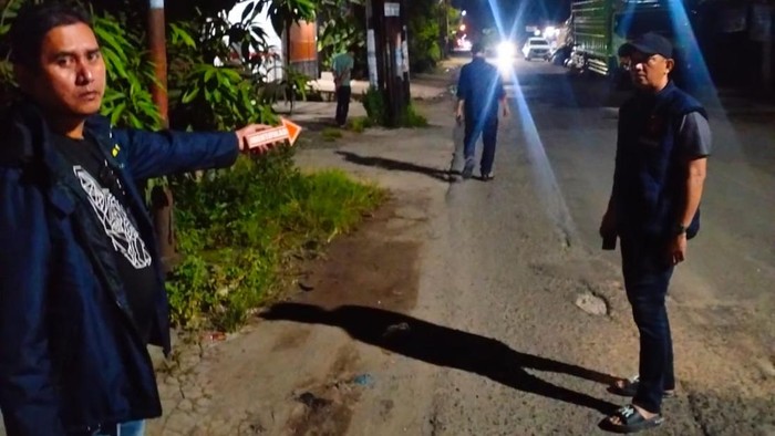 Polisi melakukan olah TKP pembacokan yang dialami jukir oleh pedagang sayur