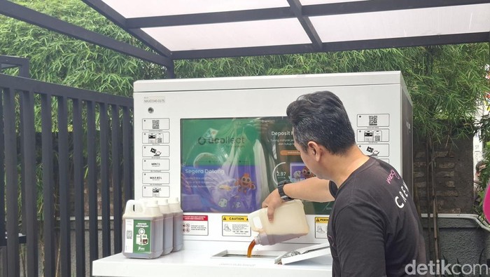 Demonstrasi memasukan minyak jelantah ke dalam mesin Ucollect Box di Hotel Moxy, Kota Bandung