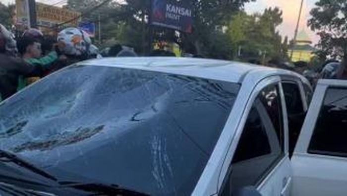 Mobil taksi online di Makassar diamuk massa hingga rusak parah.