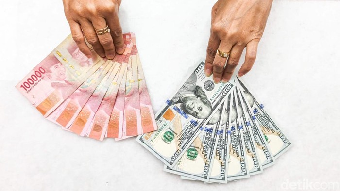 Petugas memperlihatkan lembaran uang dolar Amerika Serikat dan rupiah di gerai penukaran mata uang asing PT Ayu Masagung, Jakarta Pusat, Kamis (23/4/2026). Aktivitas jual beli valuta asing tampak berlangsung seperti biasa, namun perhatian tertuju pad