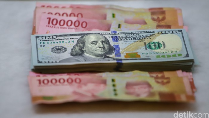 Petugas memperlihatkan lembaran uang dolar Amerika Serikat dan rupiah di gerai penukaran mata uang asing PT Ayu Masagung, Jakarta Pusat, Kamis (23/4/2026). Aktivitas jual beli valuta asing tampak berlangsung seperti biasa, namun perhatian tertuju pad