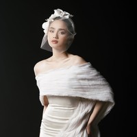 Syifa tampil dengan gaun off-shoulder yang memperlihatkan bahu dan leher, memberi kesan feminin, lembut, dan elegan tanpa terlihat berlebihan. Syifa juga tampak mengenakan veil modern yang unik dengan detail tambahan berbentuk seperti bunga di bagian atasnya. Foto: Intagram/@syifahadju