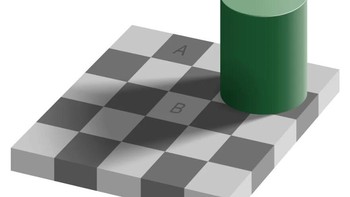 Ilusi Catur-Bayangan Adelson membuat dua kotak tampak berbeda warna, padahal identik. Otak tertipu oleh konteks bayangan dan menyesuaikan persepsi kecerahan. Coba tutupi area sekitarnya—perbedaannya akan hilang. Mekanisme ini membantu mengenali objek dalam berbagai cahaya, tapi juga bisa bikin kita salah menilai warna dan bayangan. Foto: Boredpanda