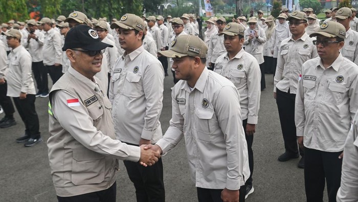 Menteri Haji dan Umrah RI Mochamad Irfan Yusuf (kanan) menyematkan simbol kepada perwakilan Petugas Penyelenggara Ibadah Haji (PPIH) di Asrama Haji Pondok Gede, Jakarta, Kamis (23/4/2026). Kementerian Haji dan Umrah melepas sekitar 200 orang PPIH Arab Saudi Daerah Kerja (Daker) Makkah. ANTARA FOTO/Fakhri Hermansyah