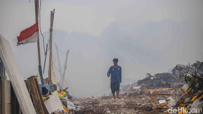 Asap pekat membumbung tinggi dari Tempat Pembuangan Akhir (TPA) di kawasan Pengangsaan Dua, Kelapa Gading, Jakarta Utara, Kamis (23/4/2026). Kobaran api yang melalap tumpukan sampah terlihat membesar sejak pagi hari, memicu kepanikan warga sekitar.  