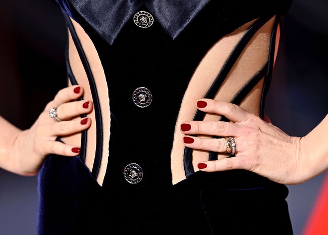 Aura seksi Anne semakin terpancar berkat bodice bergaya korset dengan detail cutout yang mengekspos kulit dan belahan rok tinggi. Aksen lapel serta kancing berlogo medusa khas Versace memberikan sentuhan yang eklektik. (Foto: Gareth Cattermole/Getty Images)