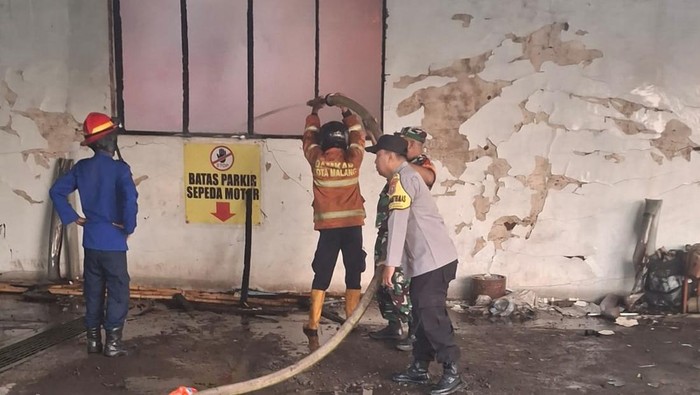 Petugas damkar melakukan pemadaman gudang rokok di Kota Malang  yang terbakar