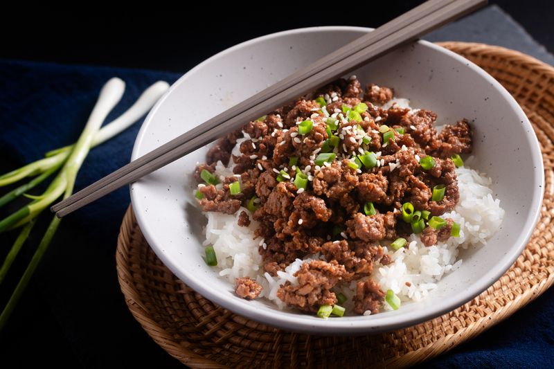 Ilustrasi nasi putih dan daging cincang Food concept Korean ground beef bowl on black background with copy space