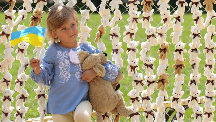 A woman places some of the 20,000 teddy bears symbolizing Russian abductions of Ukraine children during a demonstration on the National Mall in Washington, D.C., U.S., April 23, 2026. REUTERS/Kevin Lamarque