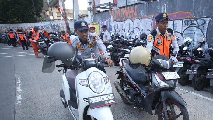 Petugas Penanganan Prasarana dan Sarana Umum (PPSU) membantu petugas Dishub memindahkan ratusan motor yang parkir liar di area Depo MRT Lebak Bulus, Jakarta, Jumat (24/4). (ANTARA FOTO/Muhammad Iqbal/sgd)