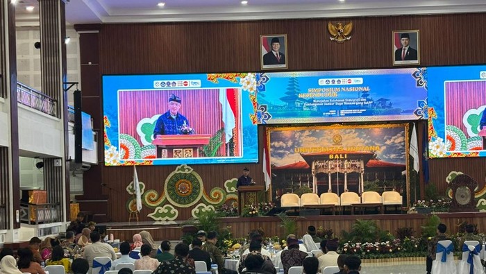 Sekjen Kemdiktisaintek, Badri Munir Sukoco, saat memberikan sambutan dalam acara Simposium Nasional Kependudukan 2026 di Universitas Udayana, Bukit Jimbaran, Badung, Kamis (23/4/2026). (Fabiola Dianira/detikBali)