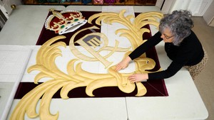 Proses bordir lambang Charles III dilakukan secara detail di studio. Royal Ballet and Opera memesan satu set tirai panggung baru untuk menggantikan tirai yang berhiaskan lambang mendiang ibu Charles, Ratu Elizabeth, yang telah terpasang di tempat pertunjukan di pusat kota London selama 27 tahun, mengawali lebih dari 10.000 pertunjukan. Foto: REUTERS/Isabel Infantes