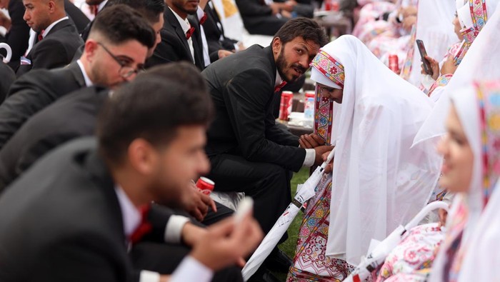 The bride and groom dance during a mass wedding of 300 couples, called ''The Dress of Joy 2,'' organized by the Al-Fares Al-Shahm Foundation, in Deir al-Balah, central Gaza Strip, on April 24, 2026. ''The Dress of Joy 2'' is a project assisting 300 grooms in the Gaza Strip to get married. (Photo by Majdi Fathi/NurPhoto via Getty Images)