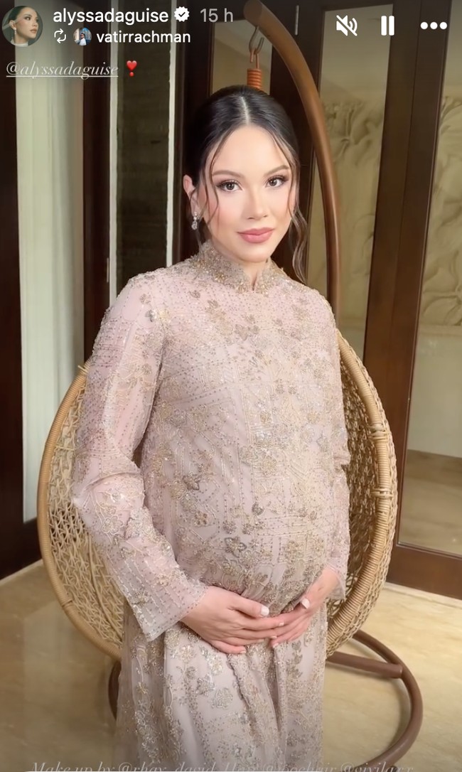 Rambutnya ditata sleek dengan belahan tengah (middle part), kemudian disanggul rapi di bagian belakang. Di sisi kanan dan kiri wajah, ada dua helai rambut yang dibiarkan jatuh (face-framing strands), memberikan sentuhan modern. Foto: Instagram/@alyssadaguise